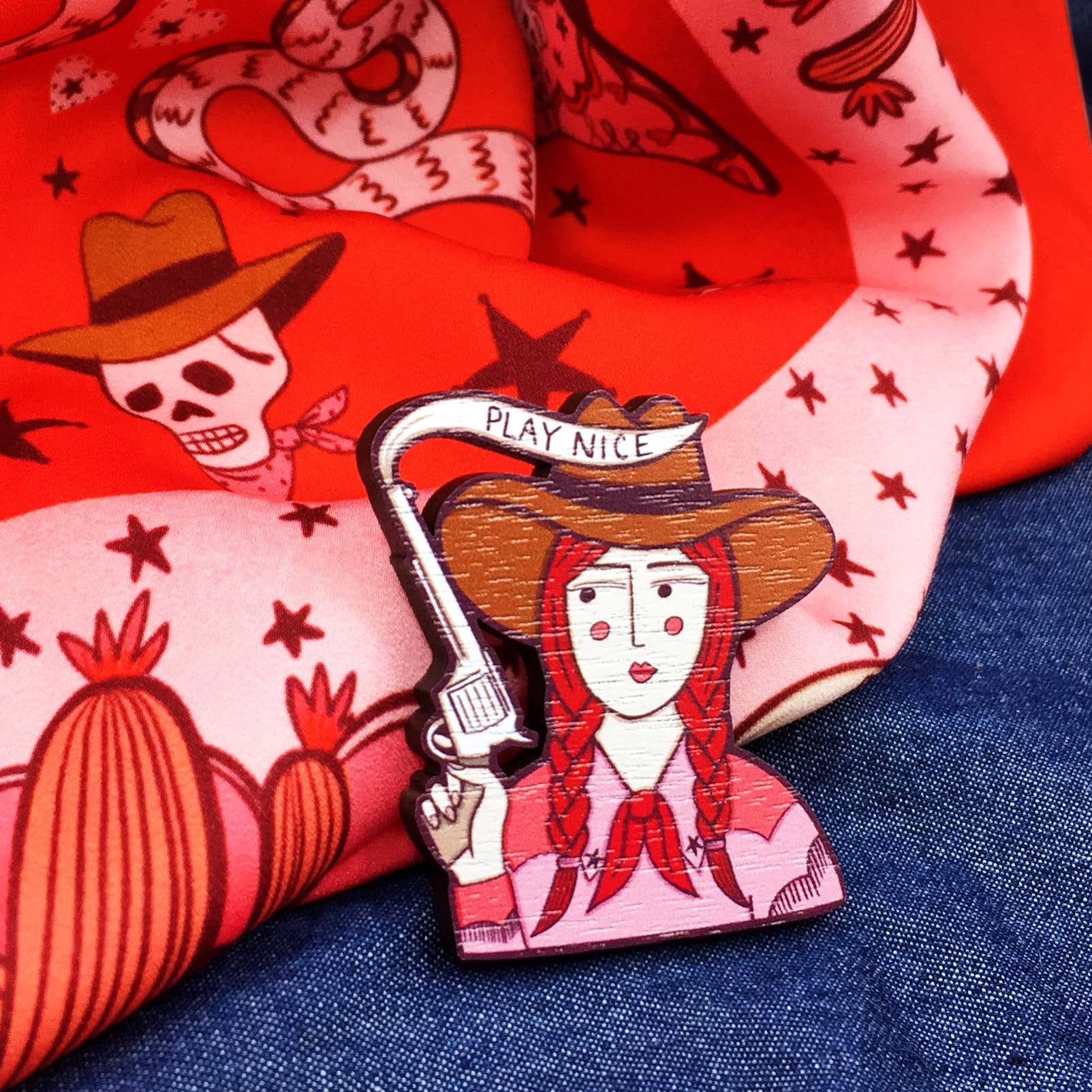 Cowgirl wooden pin brooch with 'Play Nice' message, original illustration by Su Owen, made from sustainable walnut wood, secure metal bar back, UK-made.