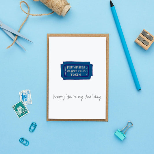 Eco-friendly, sustainably sourced Father's Day card, blank inside, displaying the humorous beer token design alongside a bright blue envelope on a natural background.