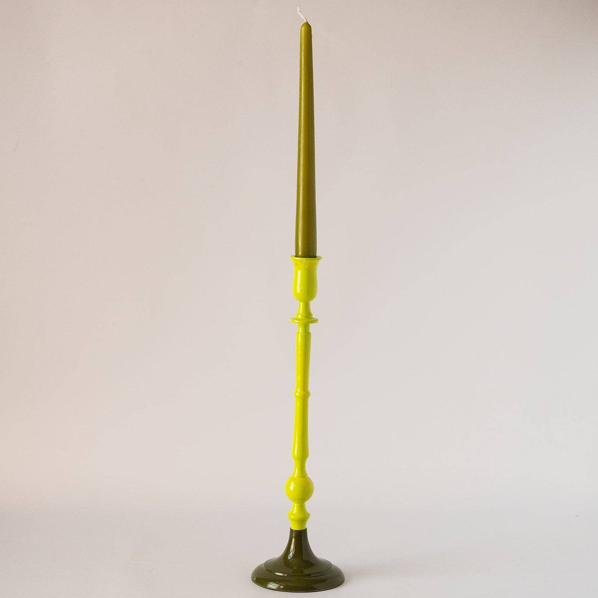 Group of tall colourful enamel candlestick holders on a dining table