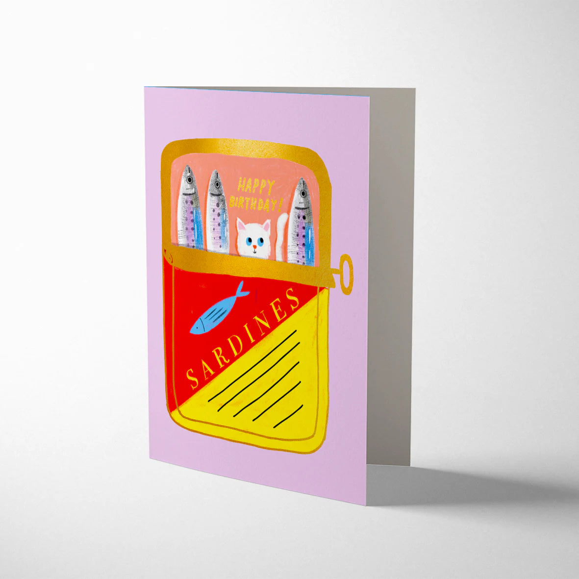 Illustration of a sardine can with fish and a cat on a pink background. Tinned Fish birthday card illustrated by Carolyn Suzuki, featuring sardine can with cat, litho printed with gold foiling and kraft envelope, size 108mm x 140mm.