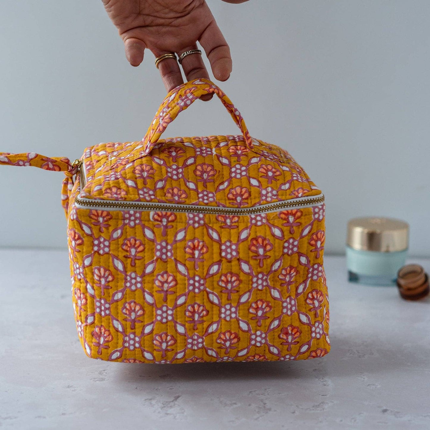 Side view of the cube-shaped floral makeup bag