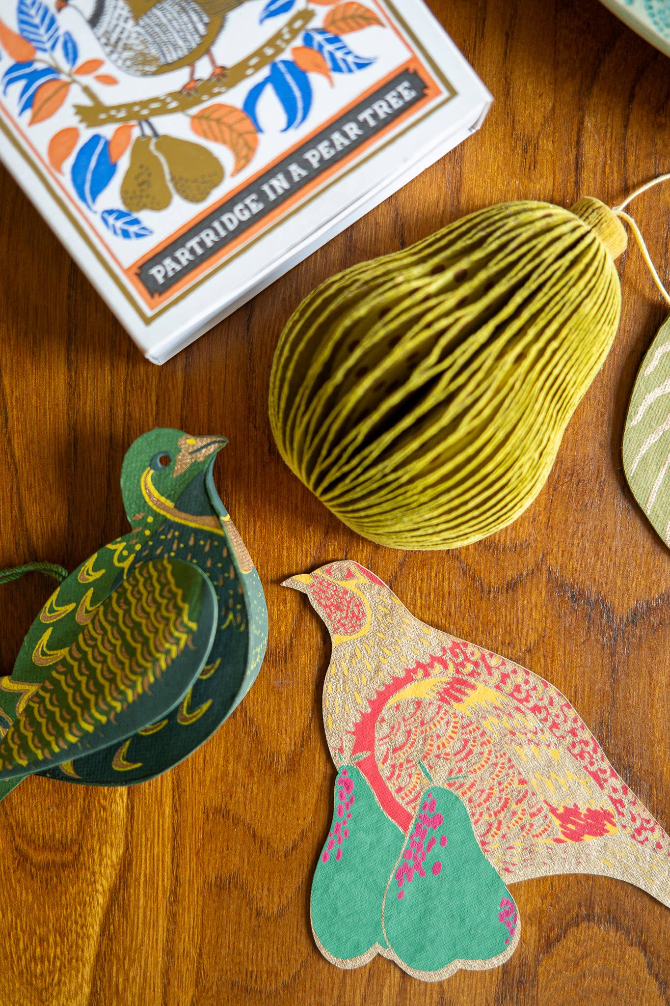 Recycled paper pear ornament illuminated by natural light