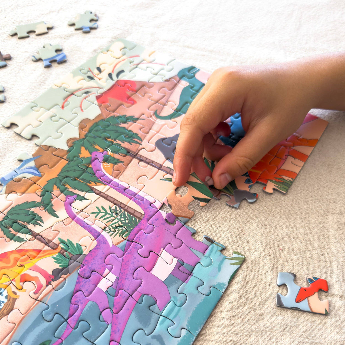 Dinosaur world puzzle pieces and tin packaging