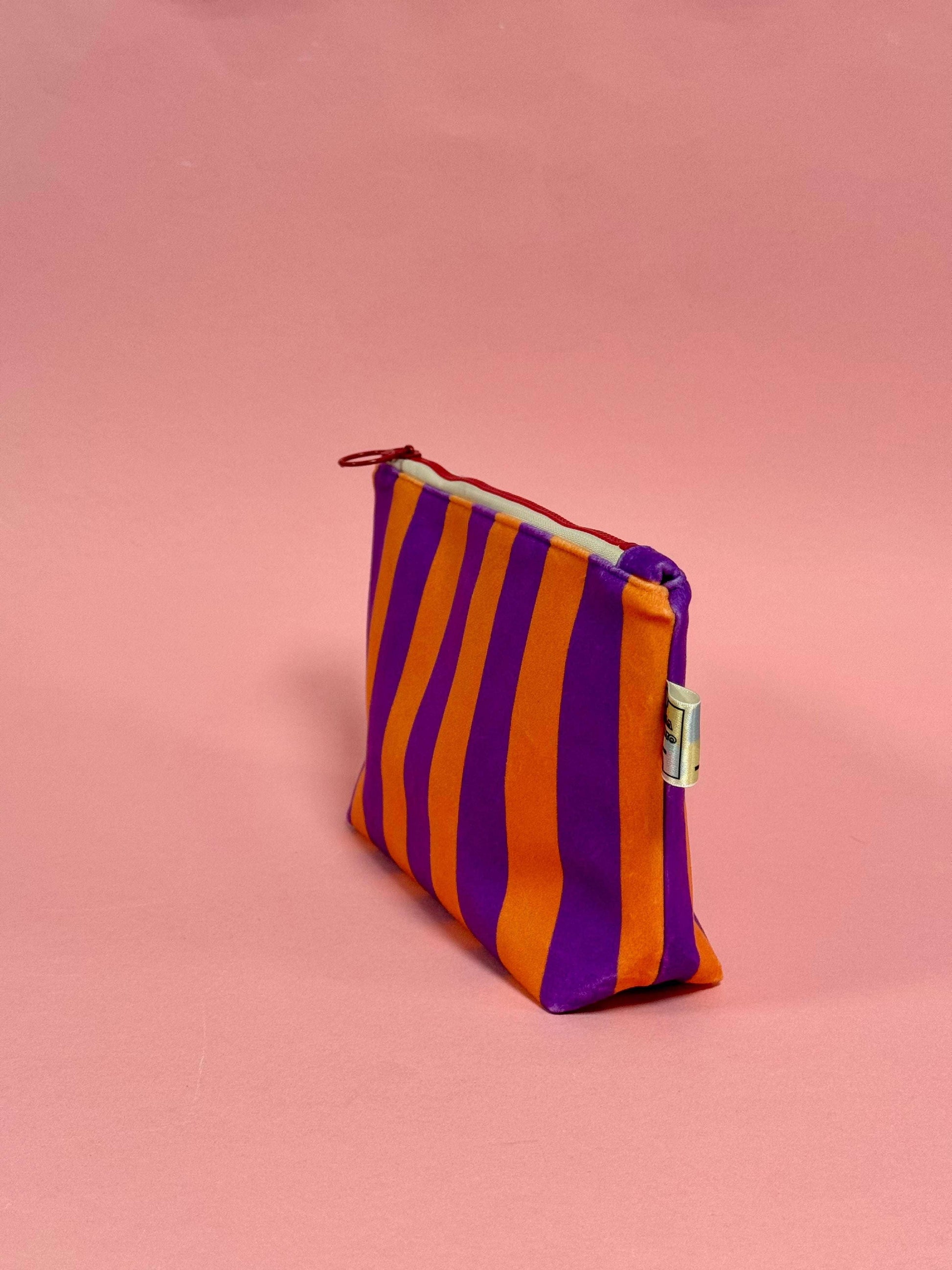 Vibrant striped velvet pouch for travel skincare and brushes