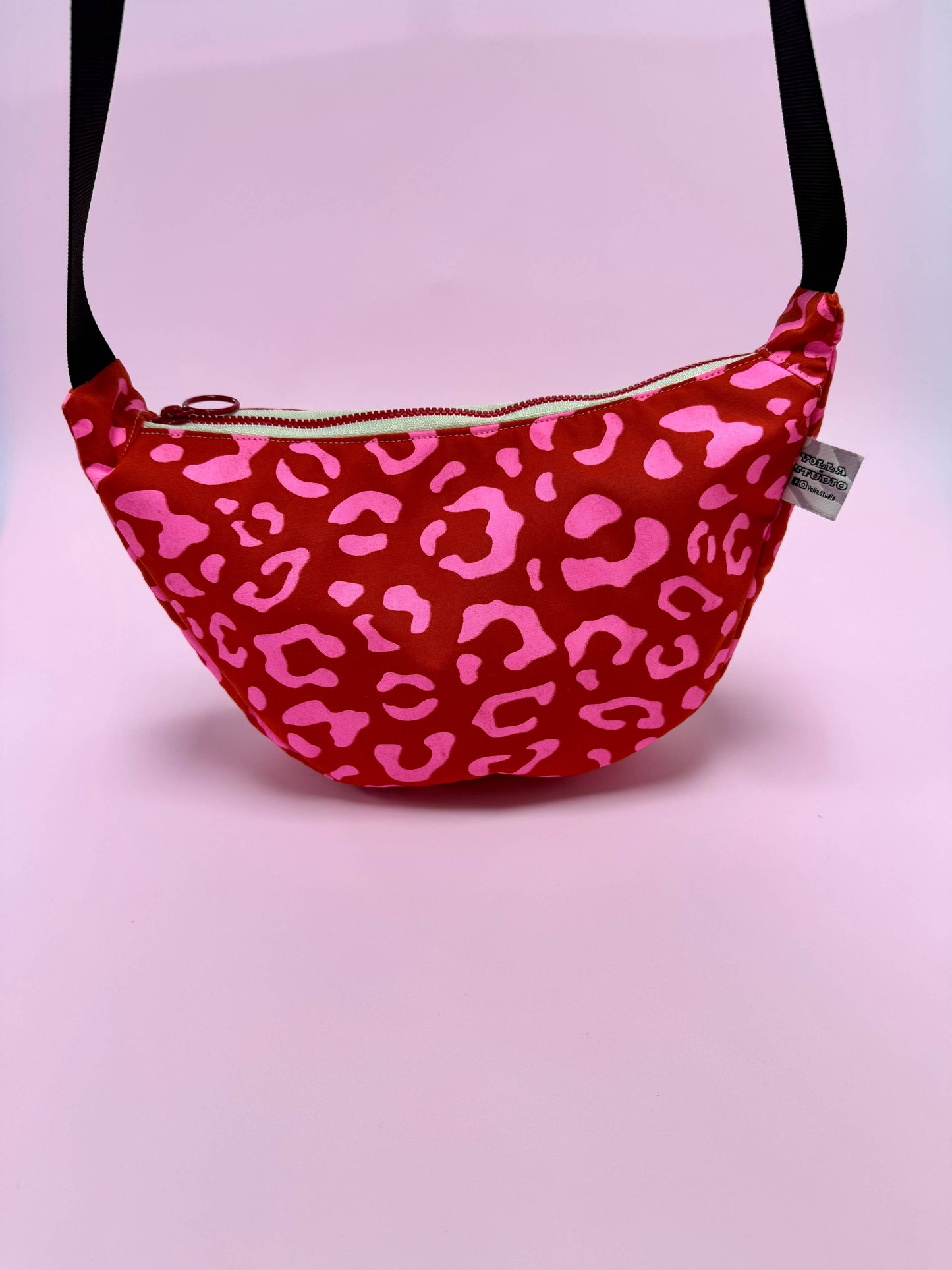 Front view of Pink Leopard on Red Handprinted Waxed Canvas Sling Bag