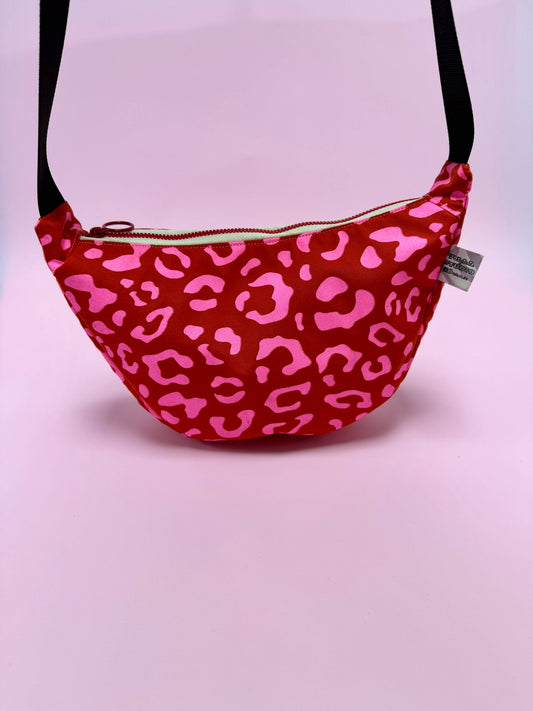 Front view of Pink Leopard on Red Handprinted Waxed Canvas Sling Bag