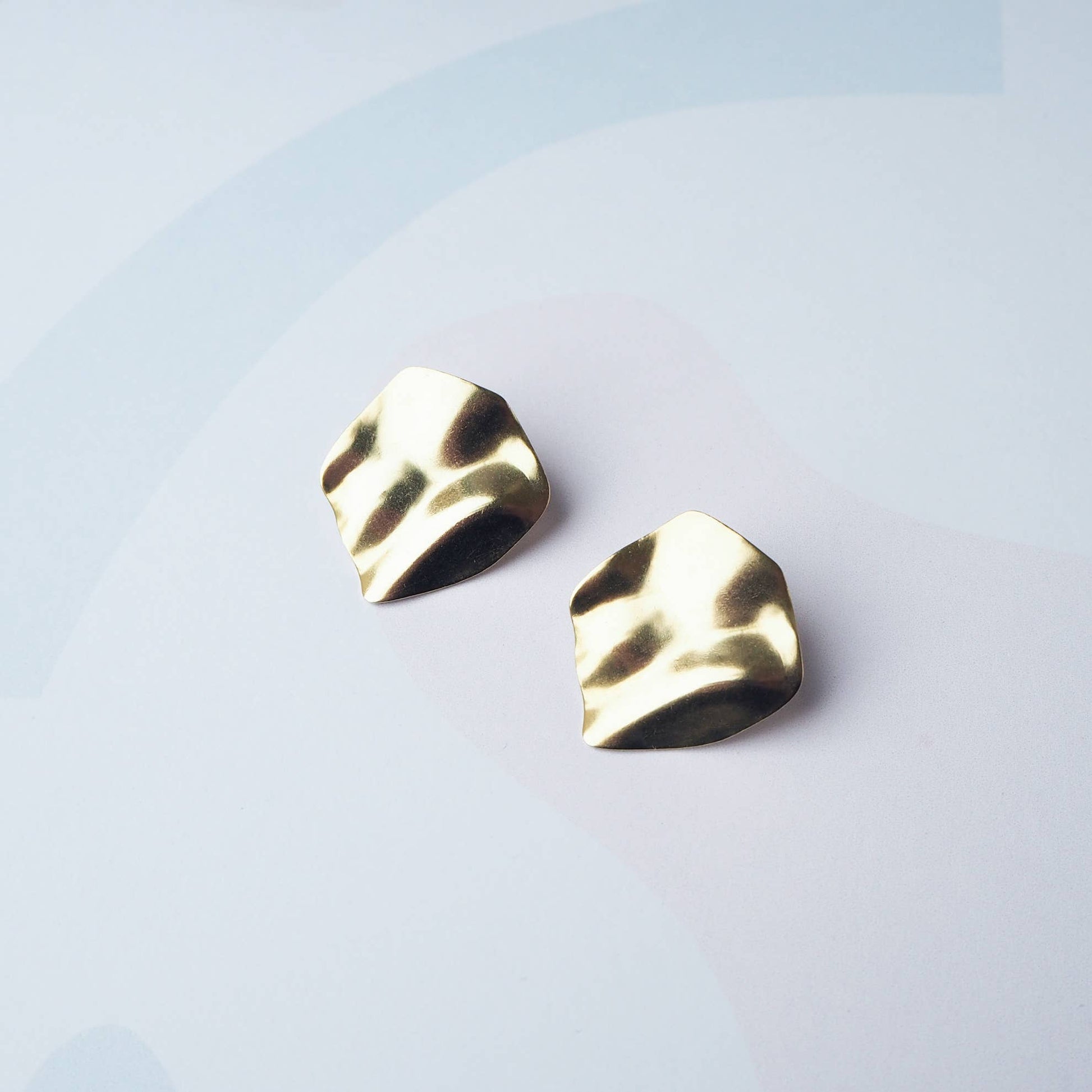 Purl wavy gold statement stud earrings flat lay