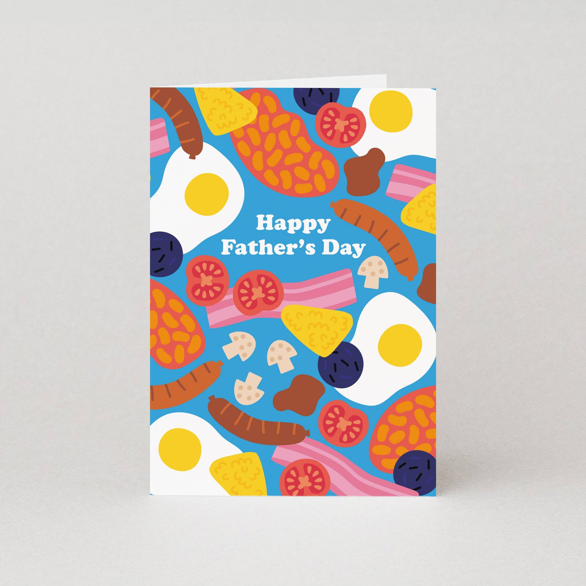Beans. Bacon. Eggs. Mushrooms. Sausages. Hash Browns. Black Pudding. This Father's Day card is serving up a Full English Breakfast, a favourite for countless dads. The delicious illustrated breakfast foods are scattered across the bright blue background of the Father's Day greeting card with its simple "Happy Father's Day" caption standing out in the middle. The inside of the greeting card is blank for a personal message to be added