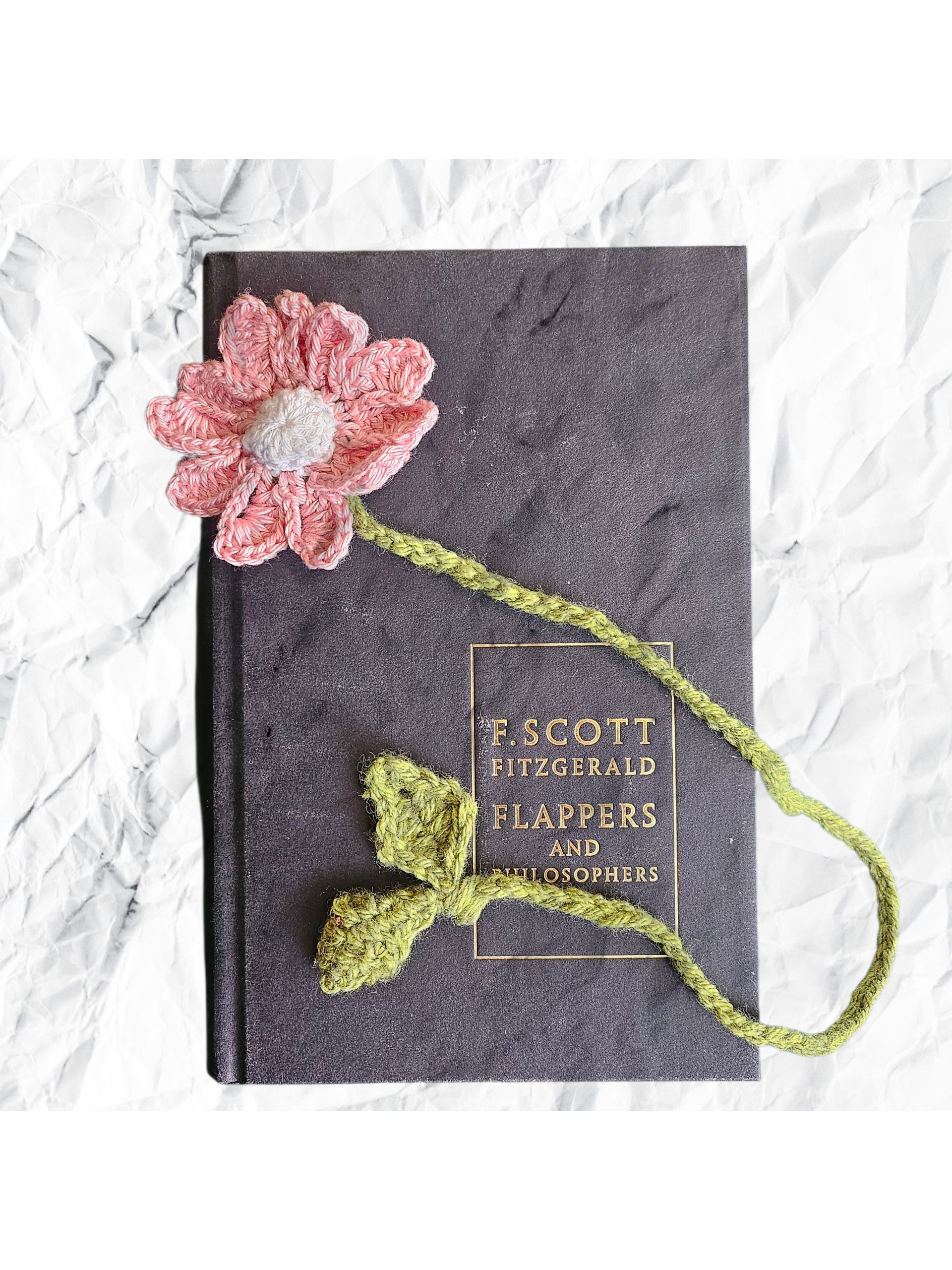 Book titled 'Flappers and Philosophers' with a pink and green crocheted flower on a textured white background