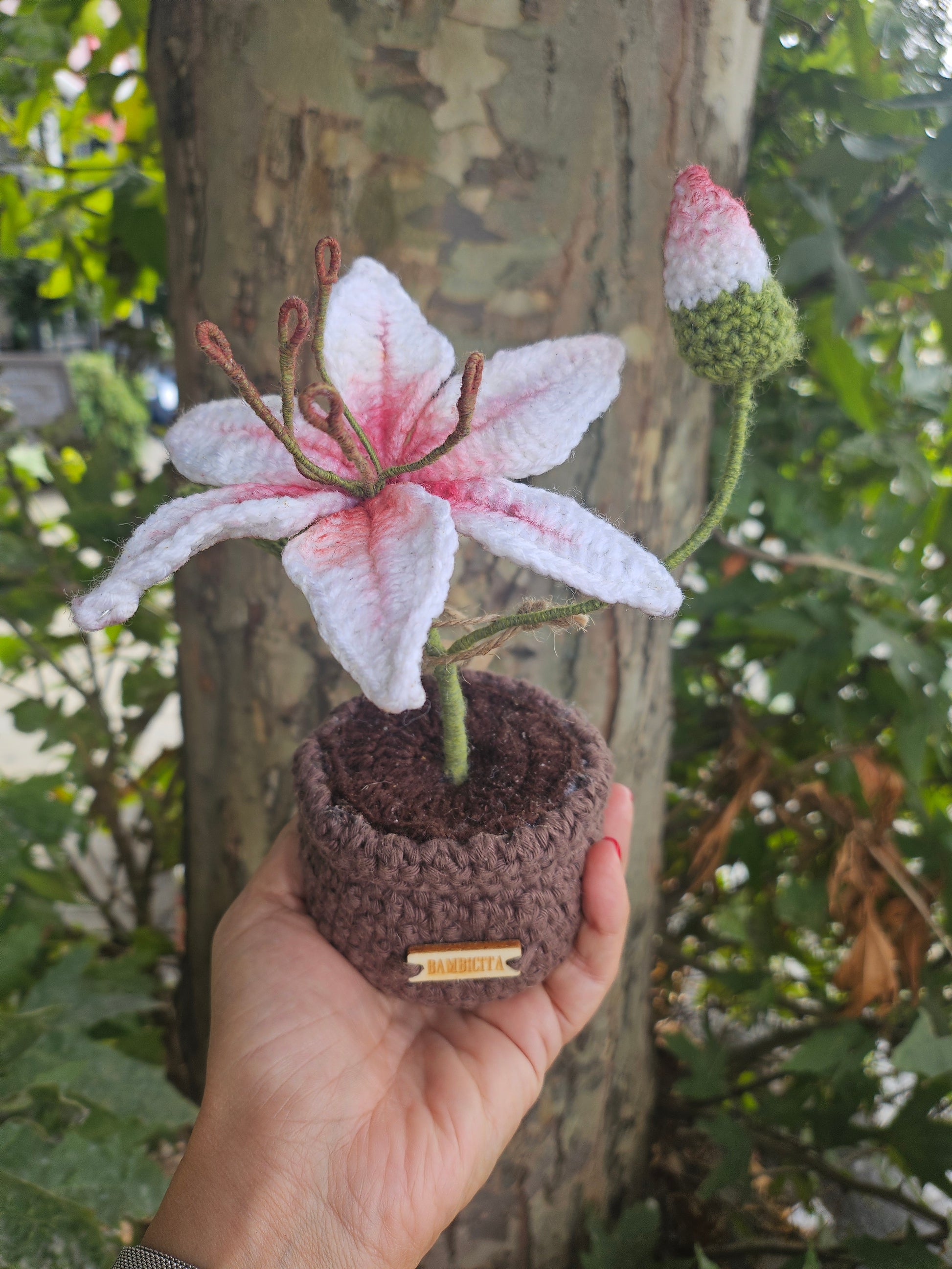 Assortment of handmade potted crochet flowers on a shelf