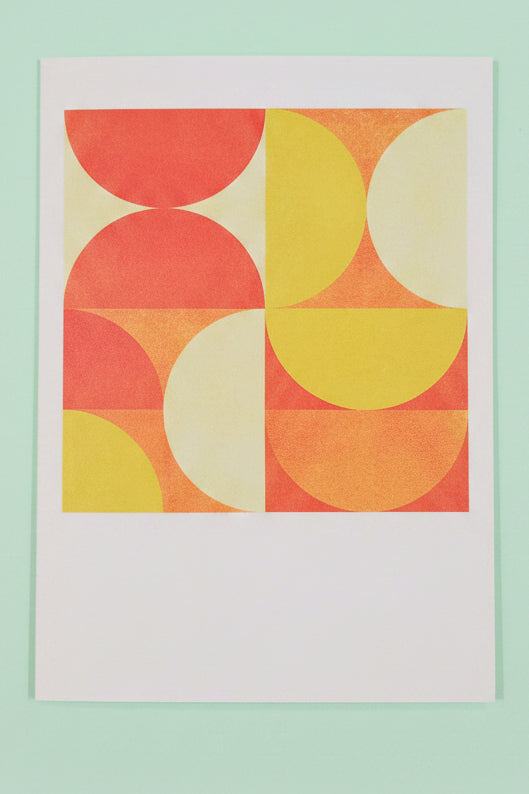 Colourful circular pattern on a white greeting card against a dark background