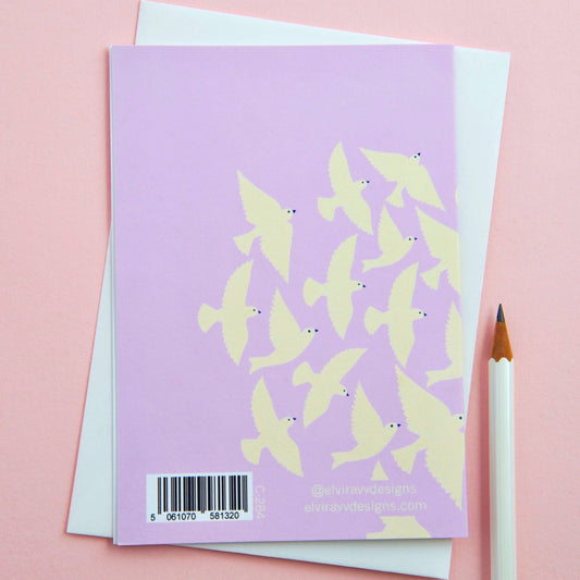 Full view of eco-friendly 'Thinking of You' greetings card with lilac birds and cream envelope.