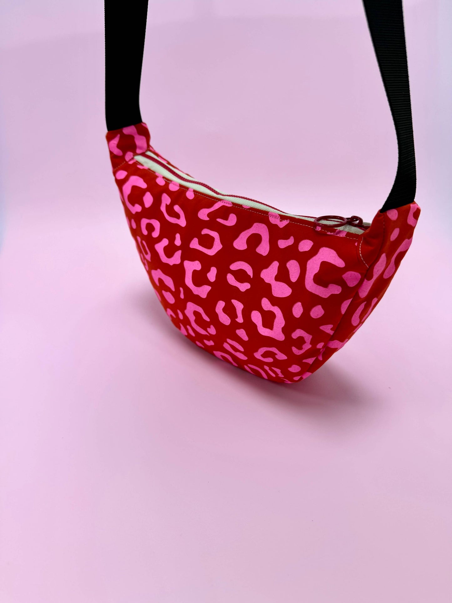 Side view of waxed canvas sling bag with adjustable strap