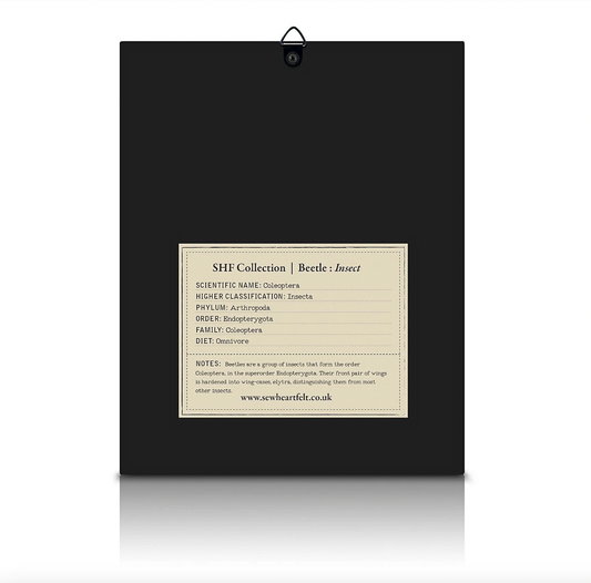 Close-up of beaded blue beetle embroidery on organic calico