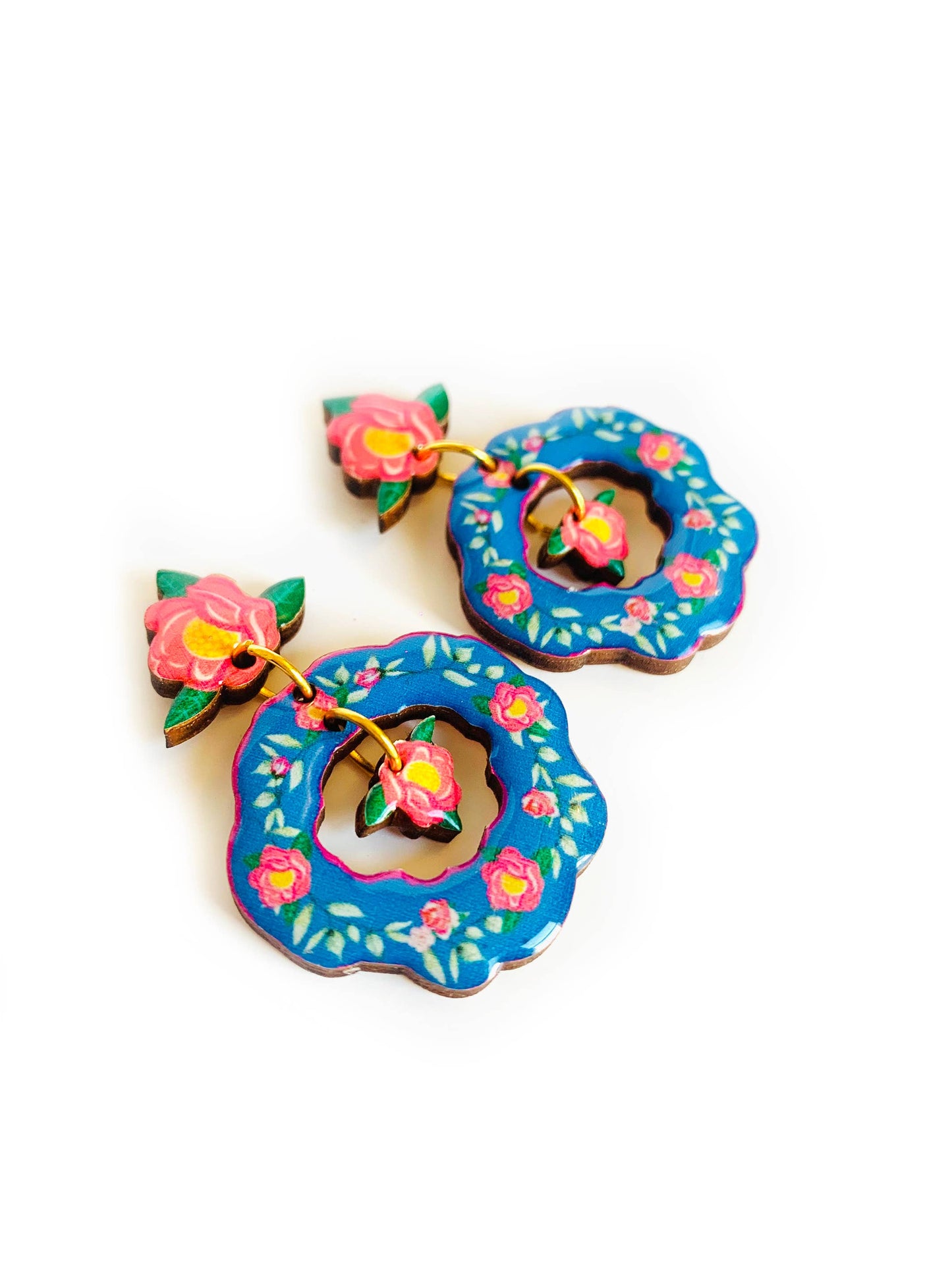Blue floral flower drop earrings which are double dangle. With a with a mini flower in the middle compartment. Blue colour with pink hues and flowers. Laser cut wood and lacquered with clear resin.