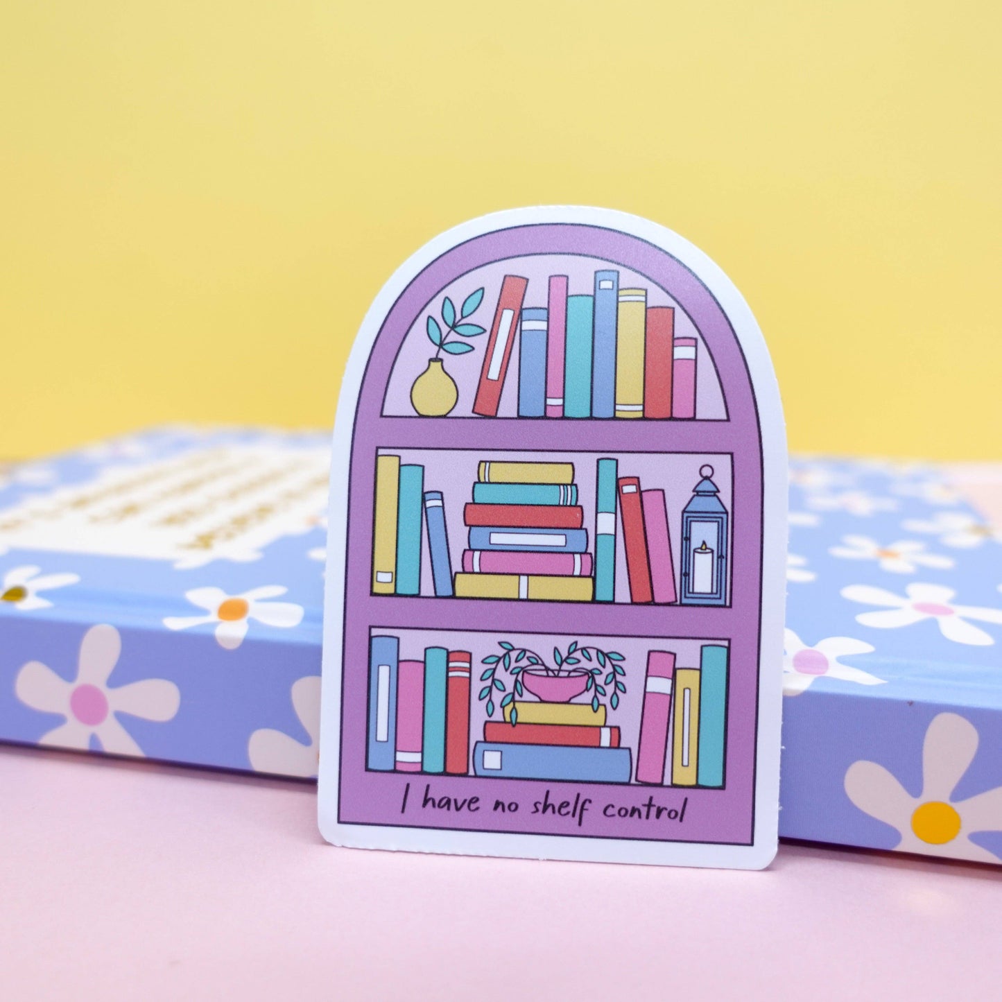 Close-up of 'No Shelf Control' bookish sticker by Sunshine Lane, featuring a detailed bookshelf illustration on waterproof vinyl.