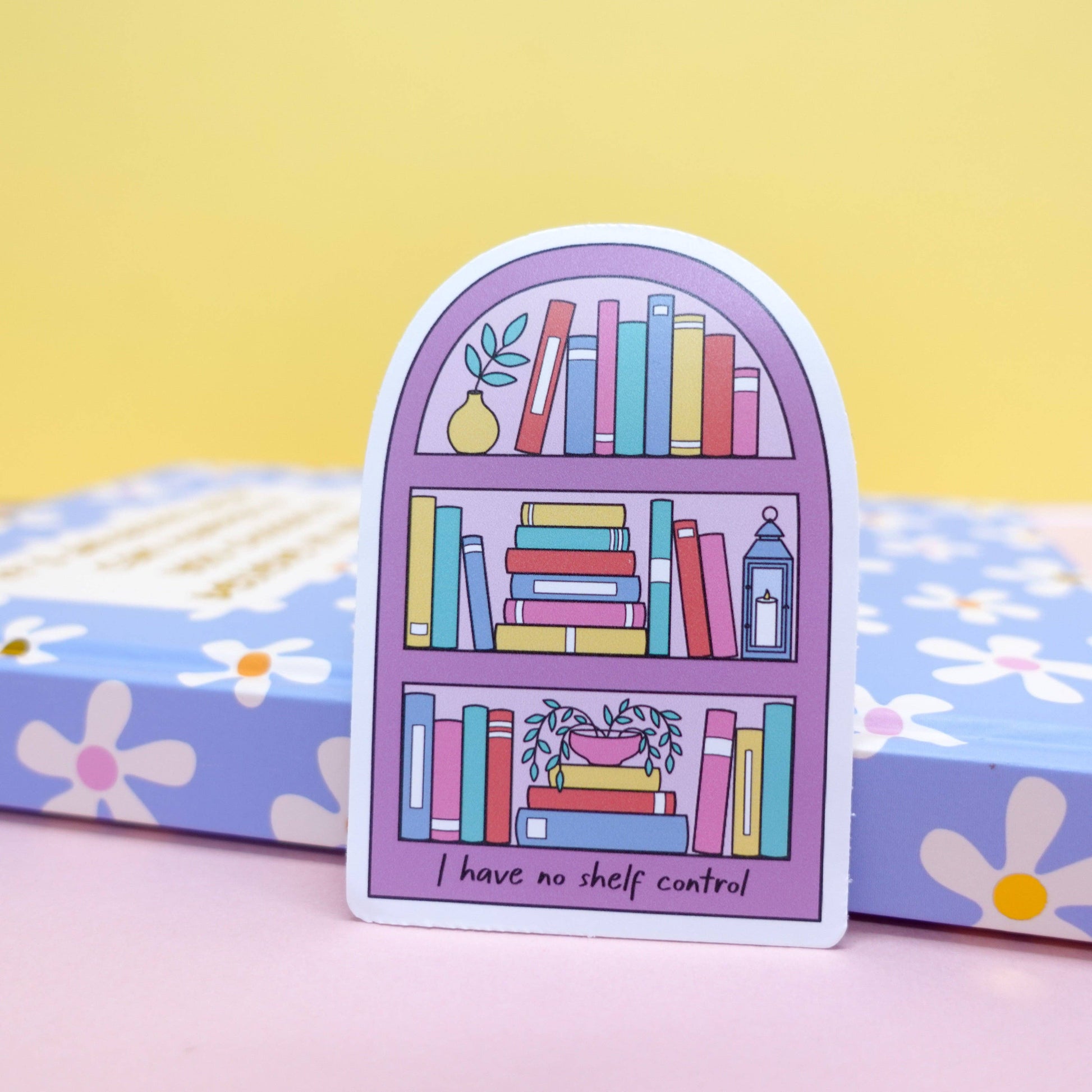 Close-up of 'No Shelf Control' bookish sticker by Sunshine Lane, featuring a detailed bookshelf illustration on waterproof vinyl.