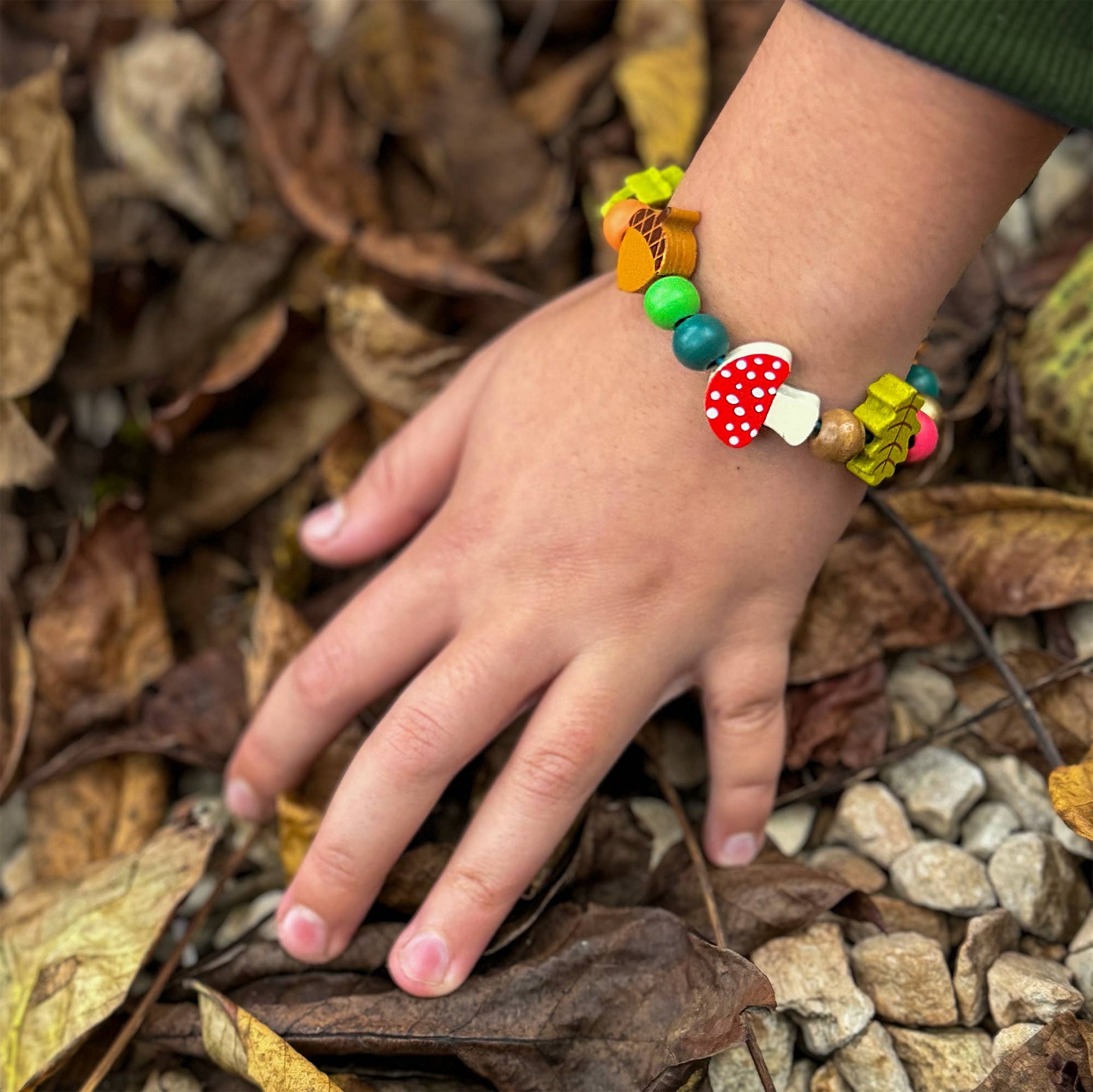 A beautiful gift tin containing elastic &amp; beads to create a beautiful wooden forest-themed bracelet. The elastic comes with metal ends to help children add beads with ease. The tin can be used to store the bracelet, or a special trinket