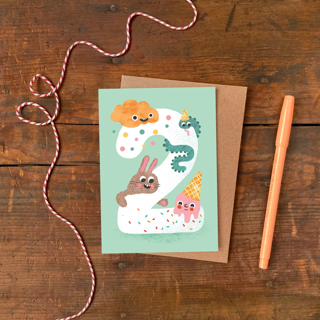 Children's Age 2 birthday card with cartoon characters on a light green background by Emily Nash. Made in the UK.