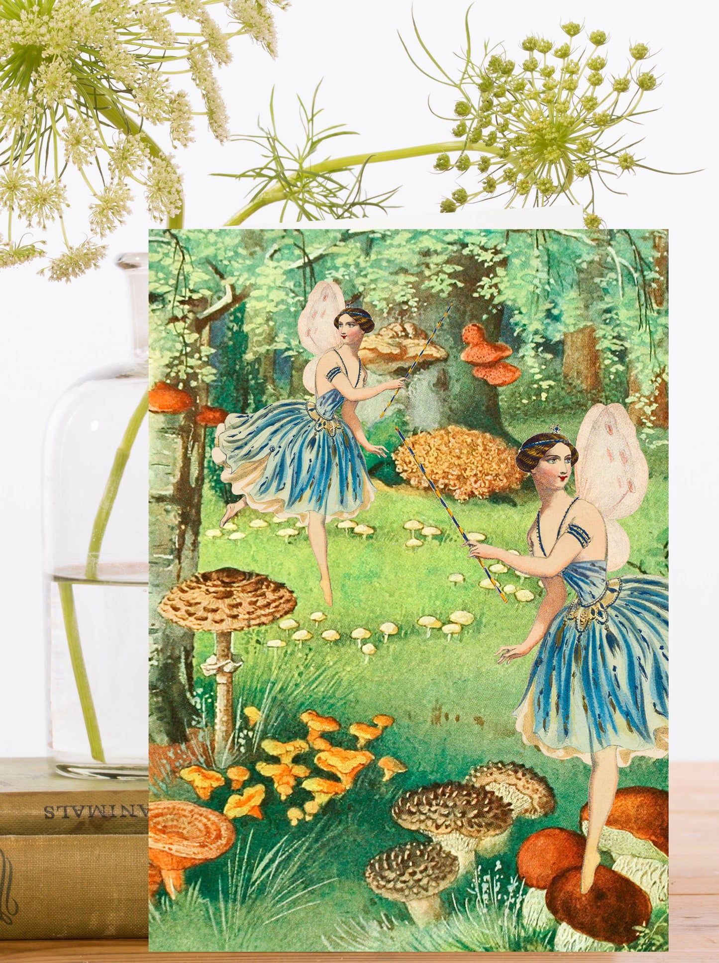 A vintage greeting card featuring fanciful fairies frolicking in a whimsical garden.
