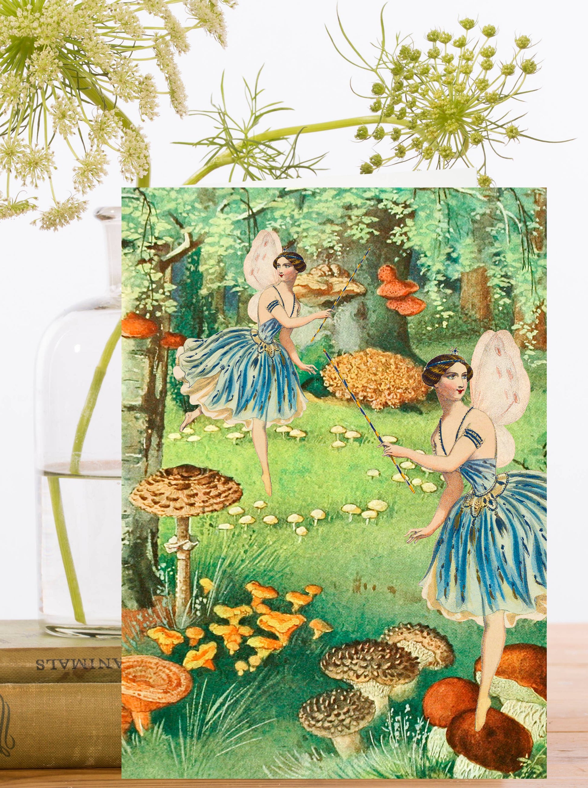 A vintage greeting card featuring fanciful fairies frolicking in a whimsical garden.