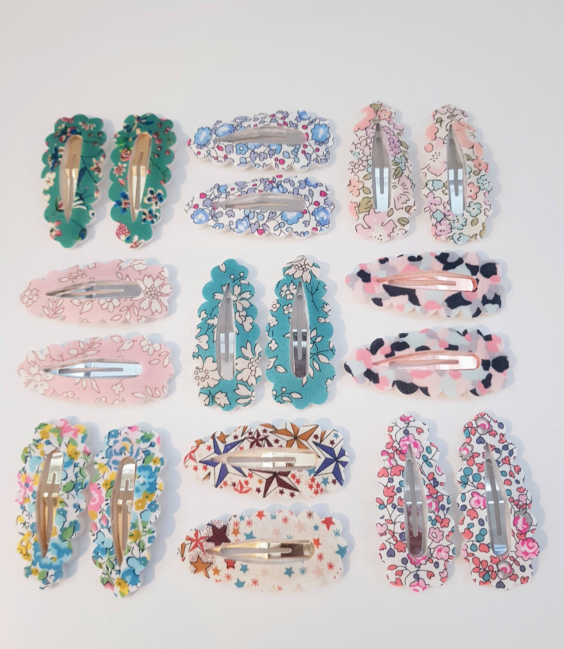 Collection of colorful floral and patterned hair clips on a light gray background