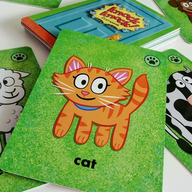 Child playing with Knock Knock! First Words game, matching brightly illustrated cards with animals and food