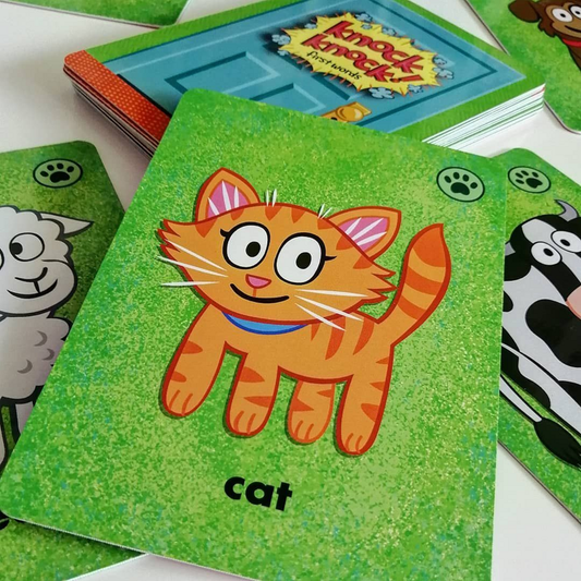 Child playing with Knock Knock! First Words game, matching brightly illustrated cards with animals and food