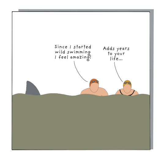 Wild Swimming greeting card by Not at all Jack with cartoon swimmers and shark fin.