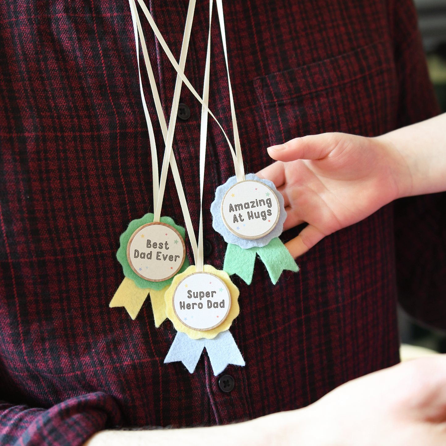 A dad wearing the handmade medals Best Dad Ever, Super Hero Dad and Amazing at Hugs