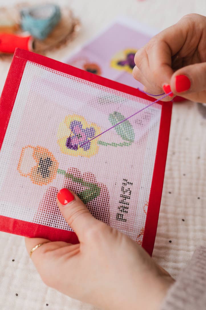 Contents of the beginner pansy needlepoint kit showing canvas and threads
