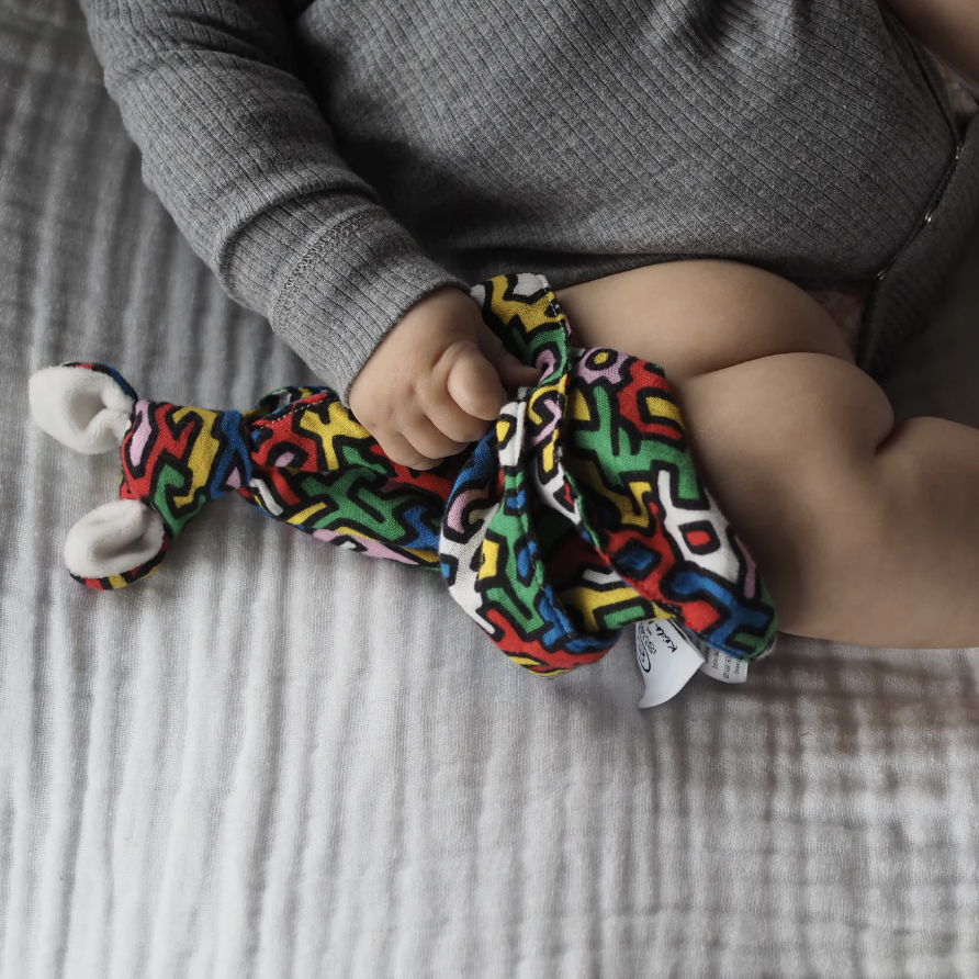 Etta Loves sensory baby comforter featuring Keith Haring ‘Brazil’ print, made from organic cotton with plush ears, 25x35cm, designed for visual stimulation.