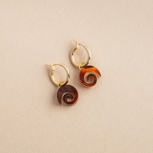 Close-up of Swirl Gold Hoop Earrings, featuring a minimalist swirl design in acrylic and sustainably sourced wood, with a gold-plated brass hoop.