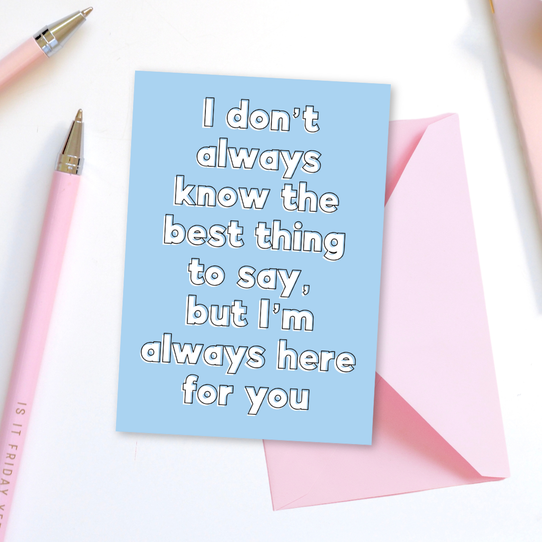Blue card with text 'I don't always know the best thing to say, but I'm always here for you' on a white background with pink pens.