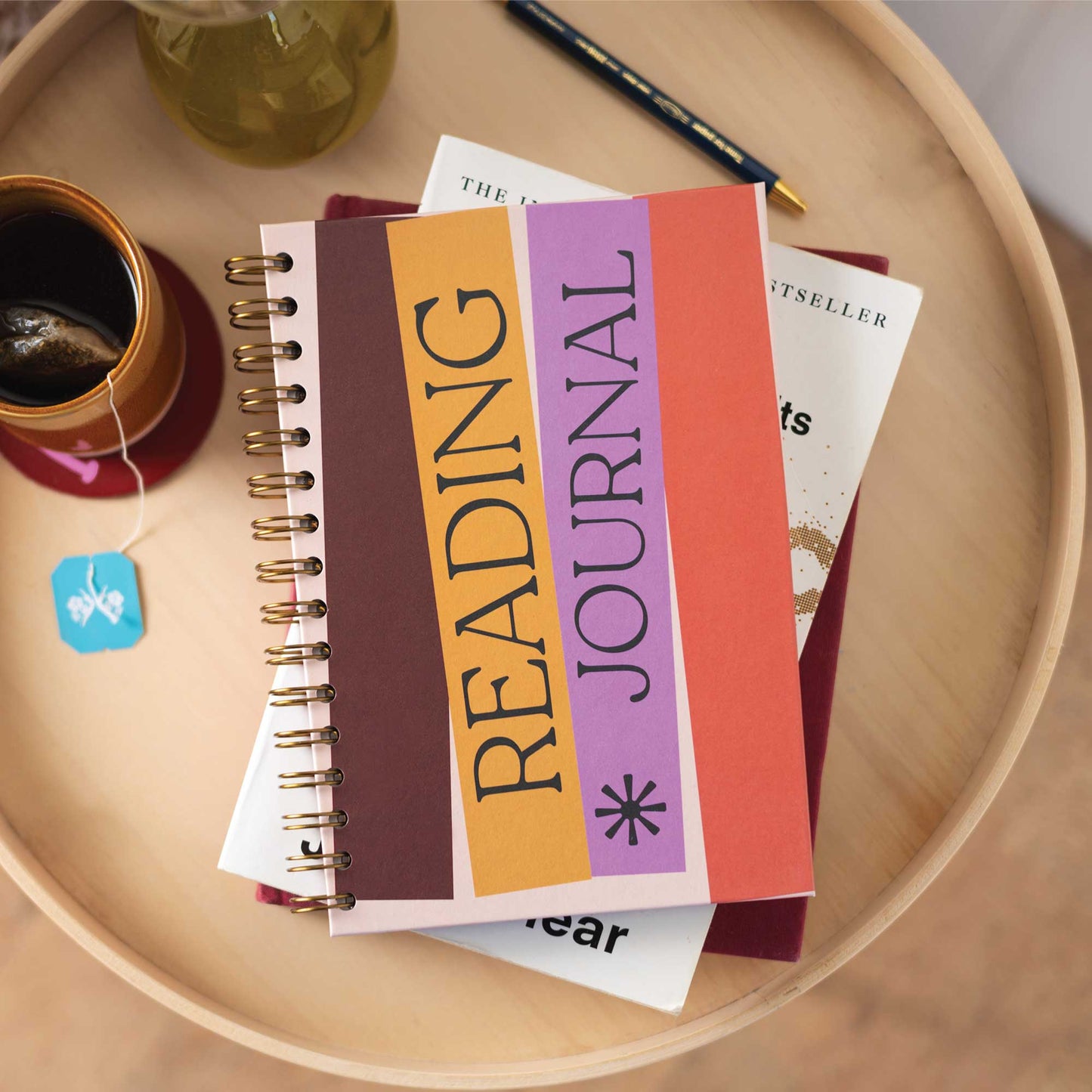 Hand holding the A5 Book Nook Reading Journal, showing its compact A5 size