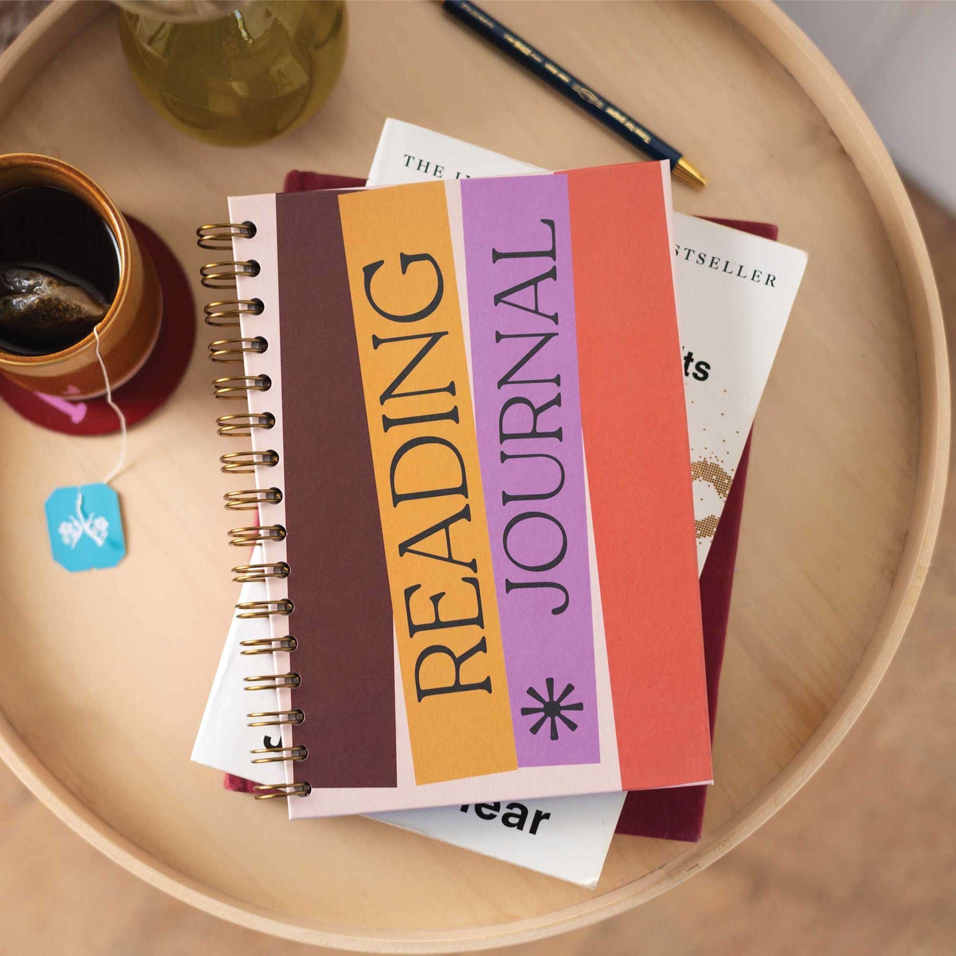 Hand holding the A5 Book Nook Reading Journal, showing its compact A5 size