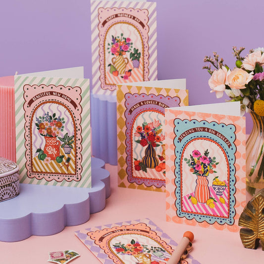 Close-up of folk art vase with flowers, fruit, and new house keys on New Home Card