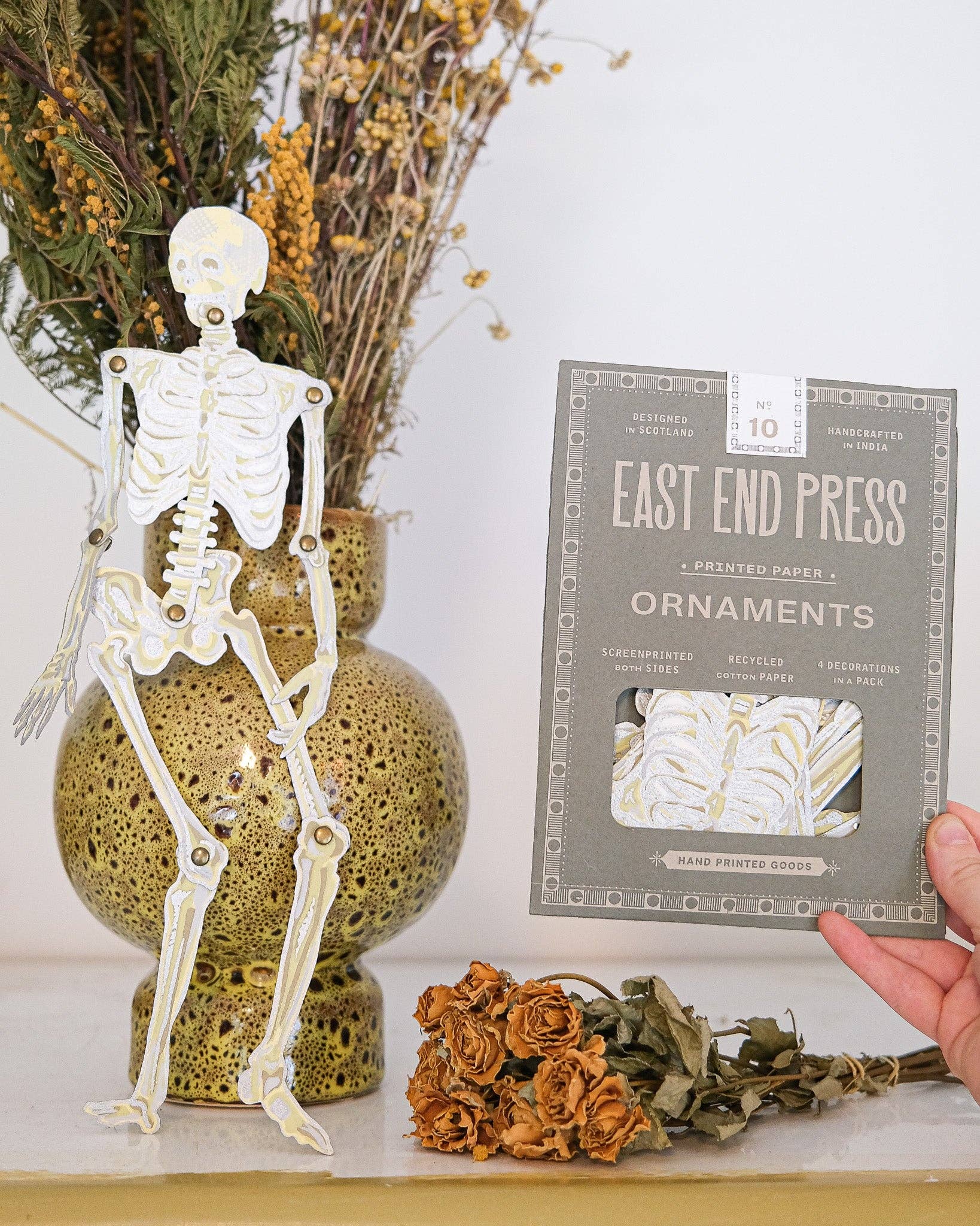 Close-up of a single dancing skeleton paper ornament with intricate hand-screen printed details.