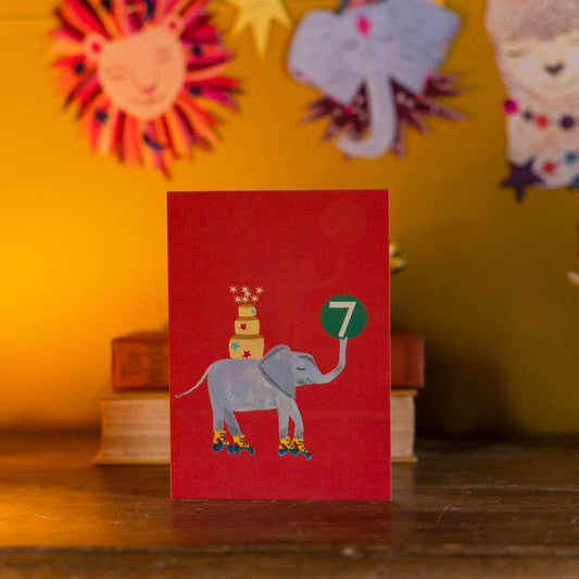 Whimsical elephant with birthday cake illustration on age 7 card