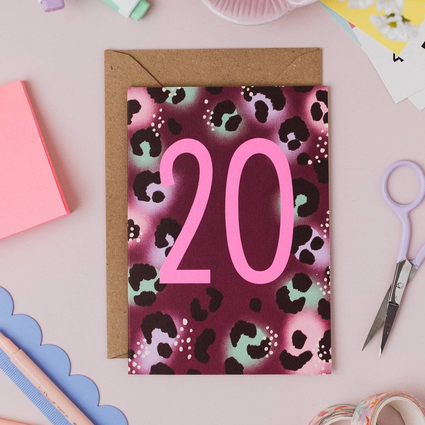 Stack of Neon 20th Birthday Cards with envelopes on a wooden surface
