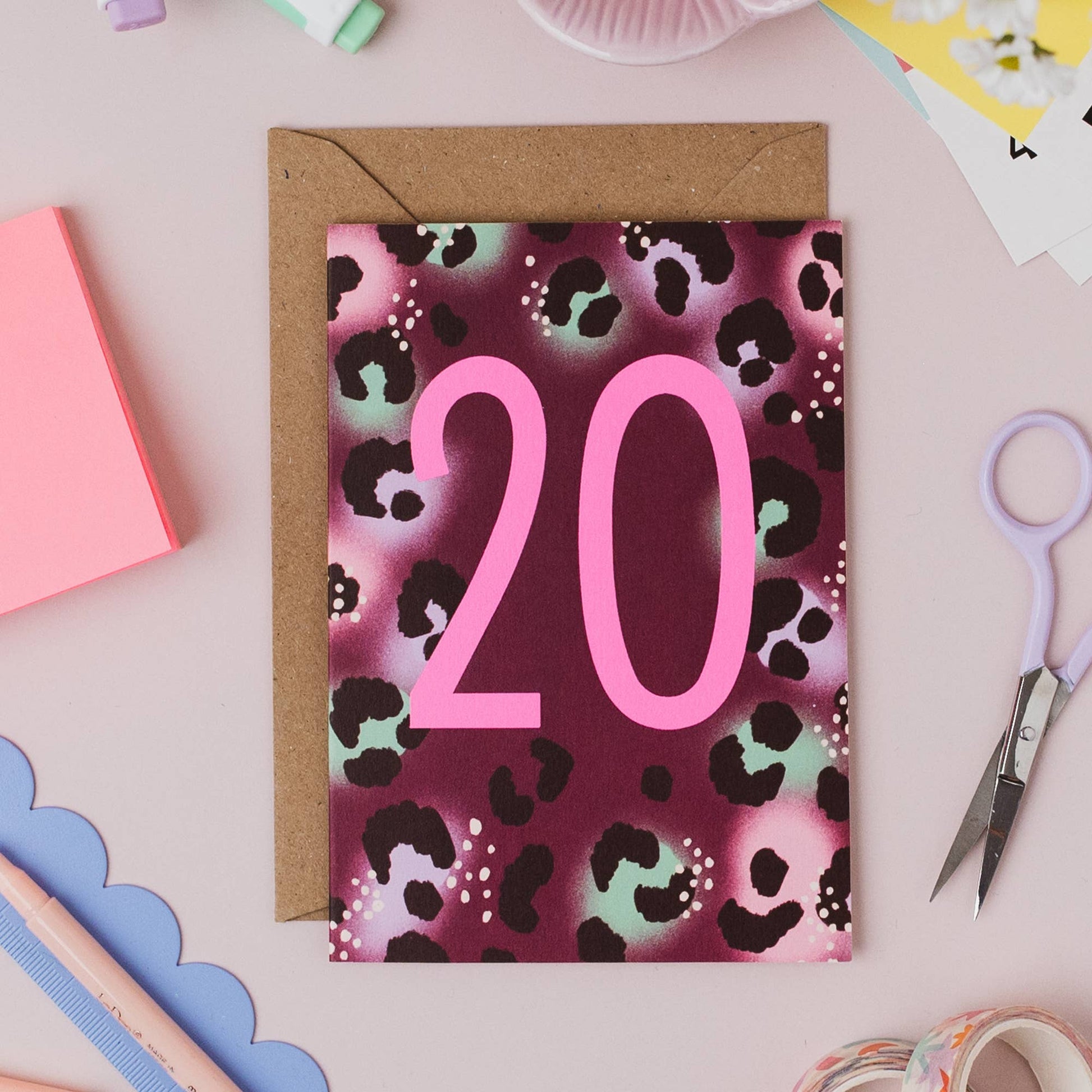 Stack of Neon 20th Birthday Cards with envelopes on a wooden surface