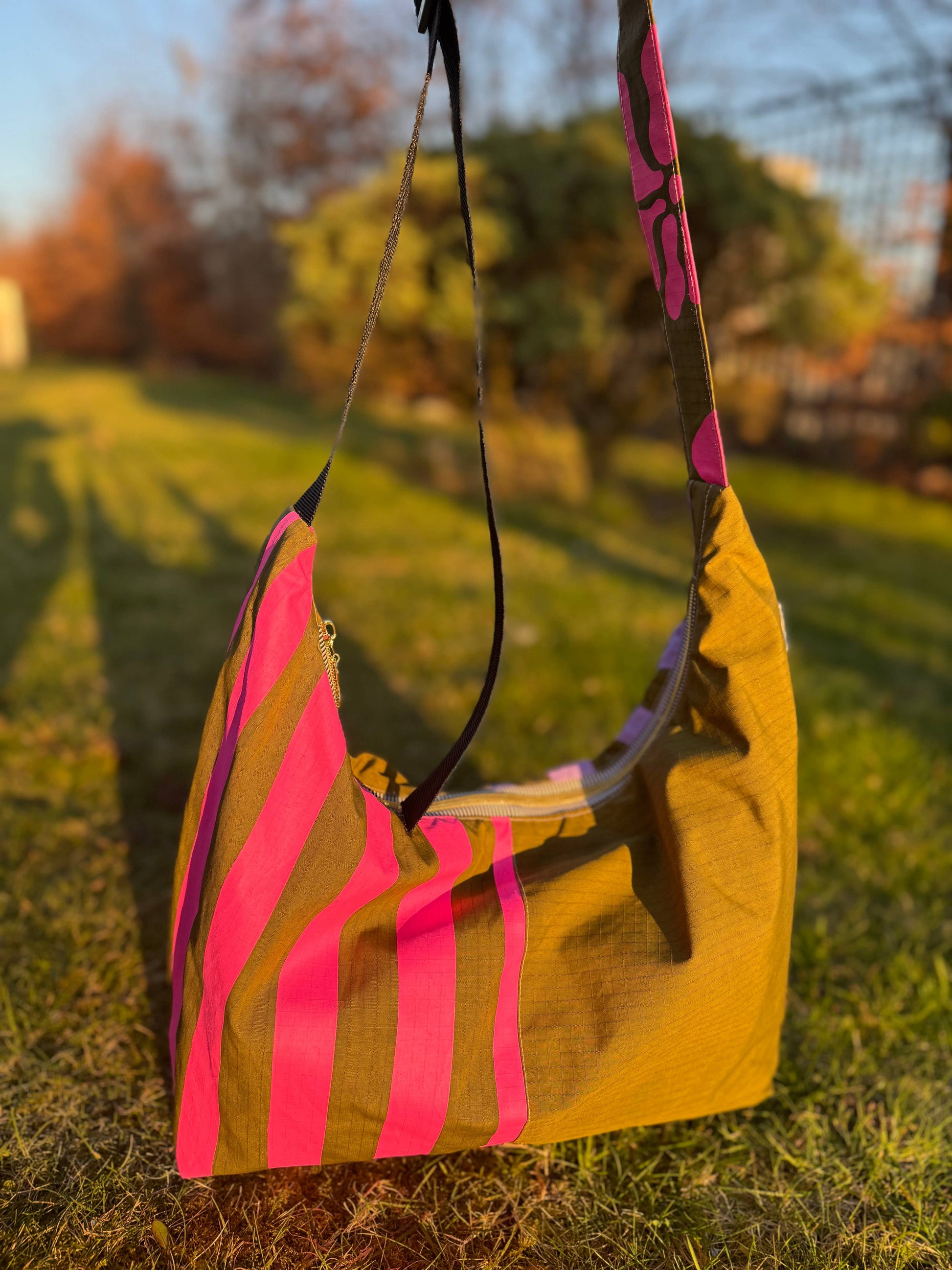 Khaki Pink Stripe Waterproof Bag, worn as shoulder bag