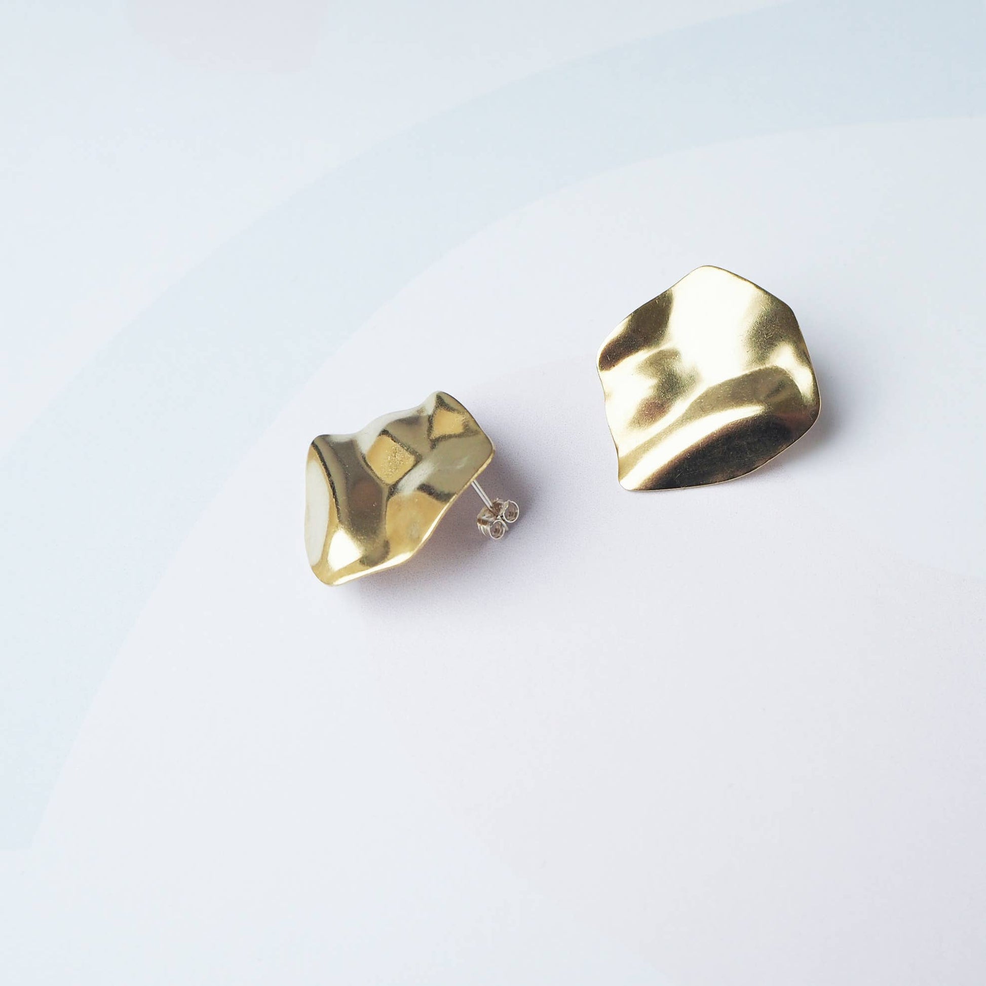 Purl modern sculptural gold drop earrings on white background