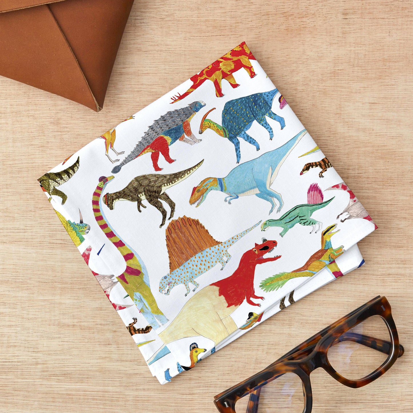 Roar into style with this playful handkerchief pocket square showcasing more than 20 illustrated dinos and prehistoric pals in a repeating pattern! Works double-duty as a dapper pocket square or practical hanky! The perfect cheeky gift or stocking surprise for fashion-forward folks who aren't afraid to show their wild side!