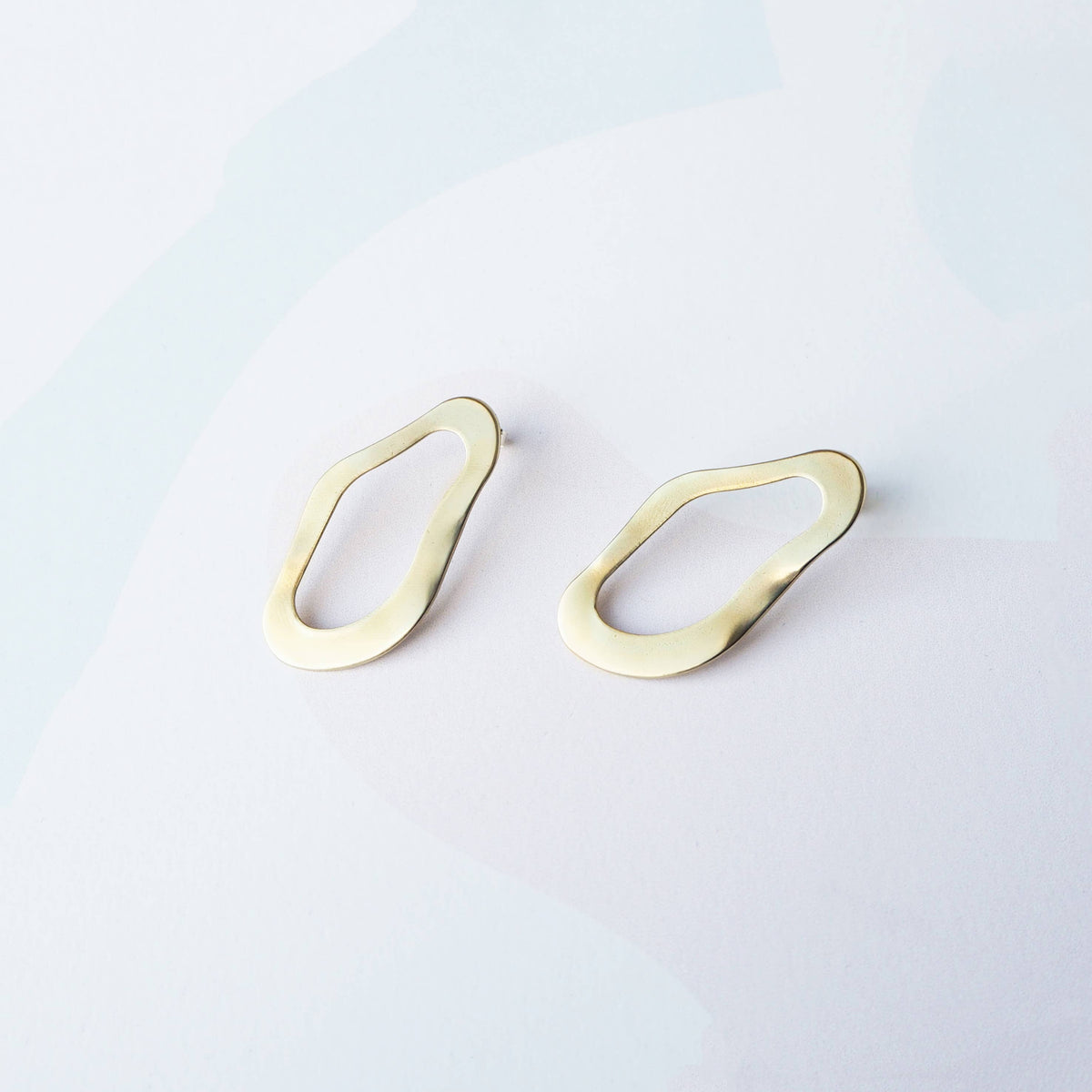 Pool wavy stud earrings flat lay