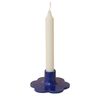 Handcrafted Solo Flower Candle Holder - Blue. Handcrafted from stoneware clay, this colourful candle holder is ideal as a decorative focal point for your dining table, mantlepiece or nightstand. The base is in the shape of a flower. 10cm wide x 4cm high