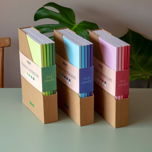 Set of five gradient A5 notebooks standing upright in a card folder