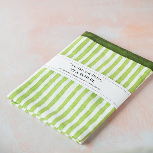 Green stripe cotton tea towel hanging in a kitchen