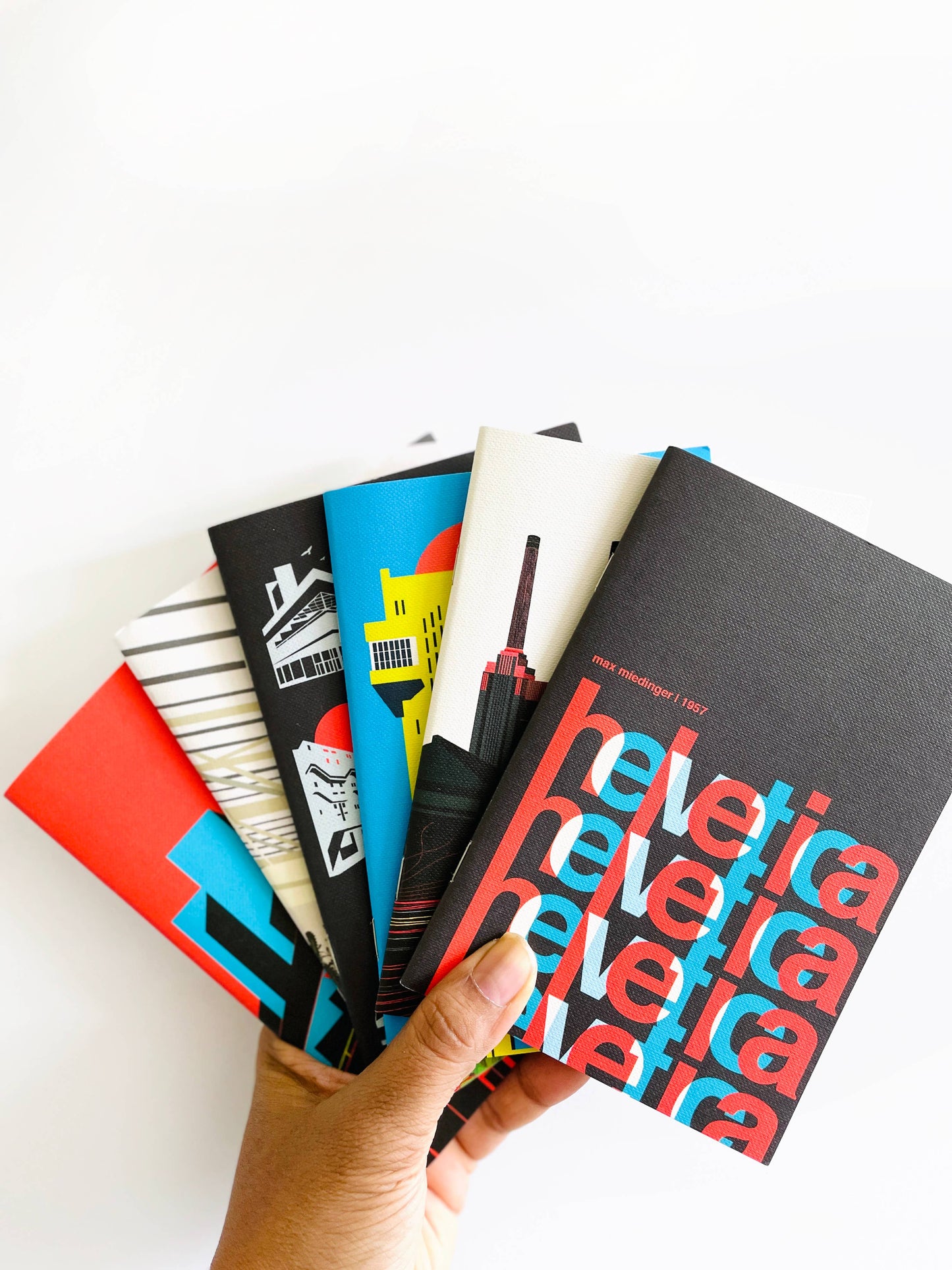 A selection of pocket size brutalist notebooks from Eye For London. In bold black, red, blue and yellow tones.