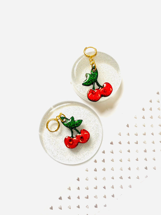 Stunning cherry earrings with huggie gold plated hoops. Laser cut wood design. Cute cherry illustrated earrings piece with red ruby gems. Professionally cut via a laser. Hard resin hand applied with glitter